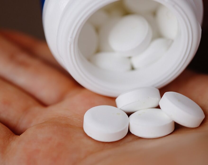 Mano con pastillas blancas